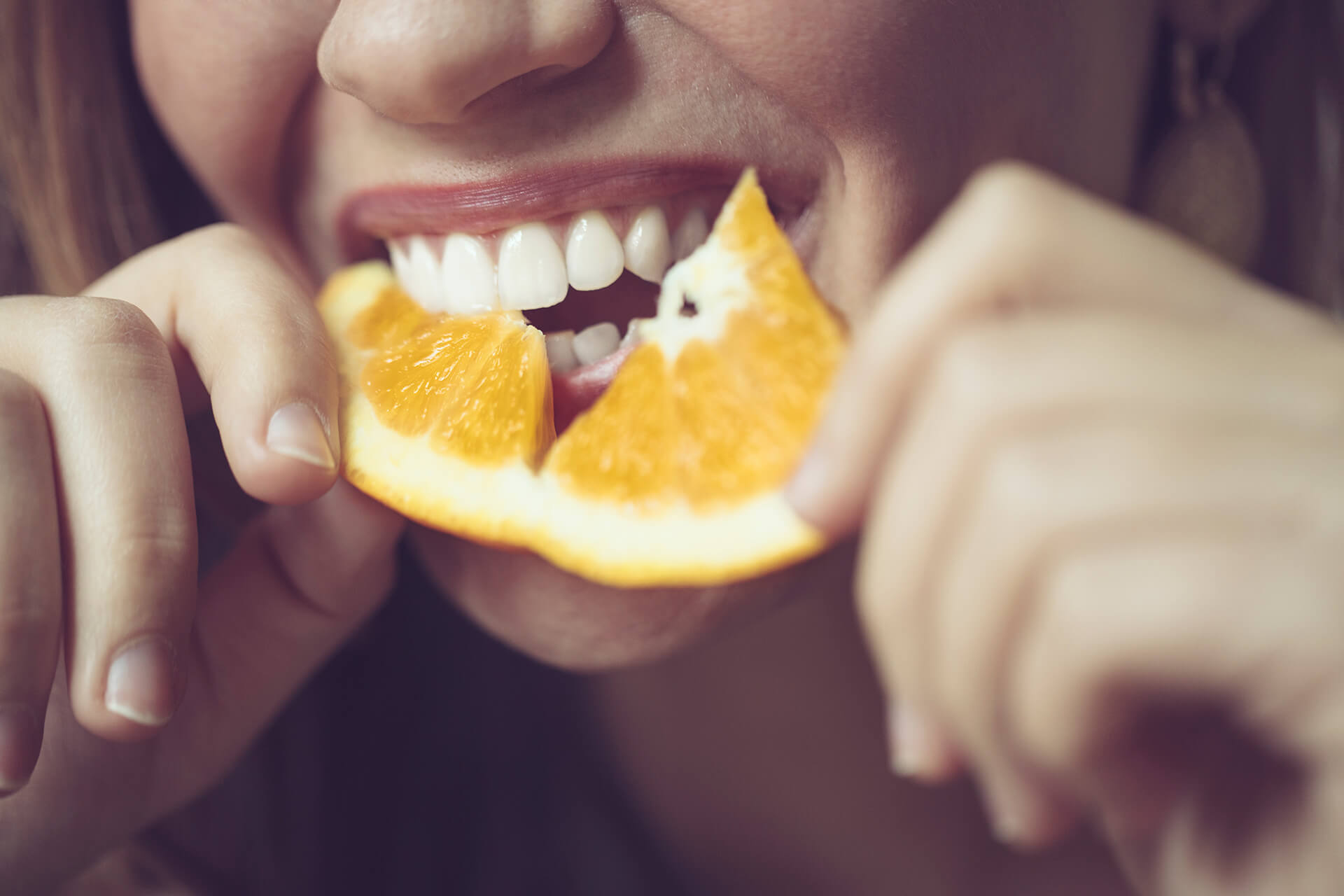 Bilde av en dame som spiser appelsin.